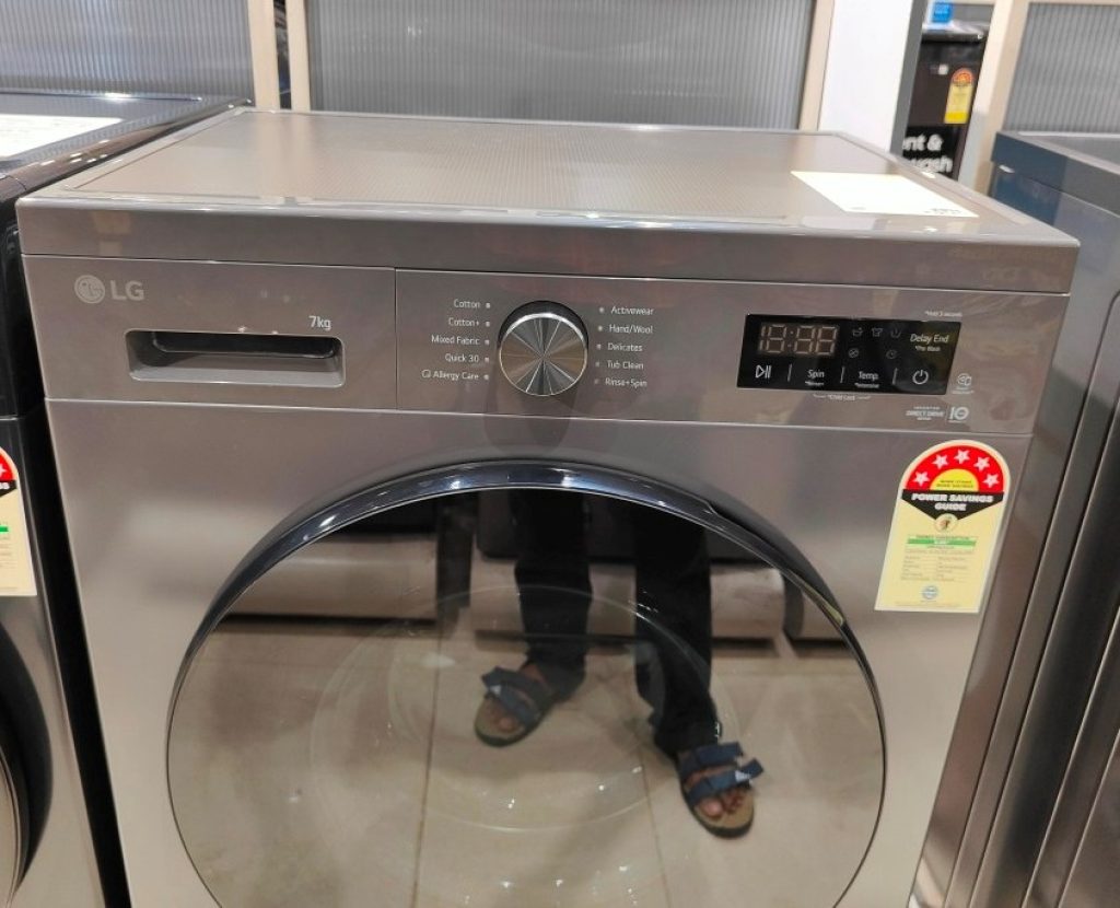 Front view of an LG FHB1207Z2M 7 kg front‑load washing machine, the top control panel with washing‑programme selector dial and digital LED display.