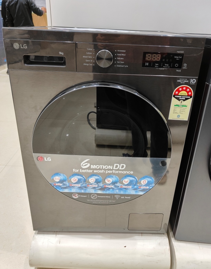LG 9 Kg 5 Star front‑load washing machine (model FHB1209Z2M) with large round plastic door and digital control panel on top